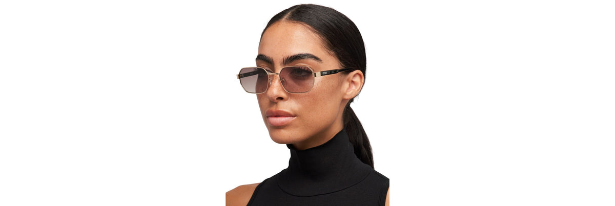Hands holding sunglasses under natural light, checking a hinge screw with a mini precision screwdriver and a microfiber cloth nearby.