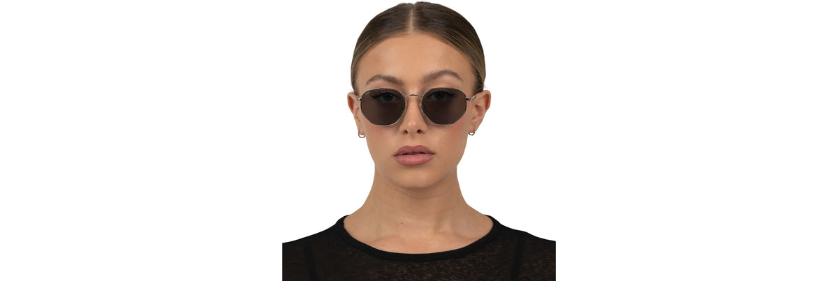 Three people with different head sizes wearing proportional oversized sunglasses—one slim cat-eye, one chunky rectangle, and one soft butterfly—shot in bright, natural light.