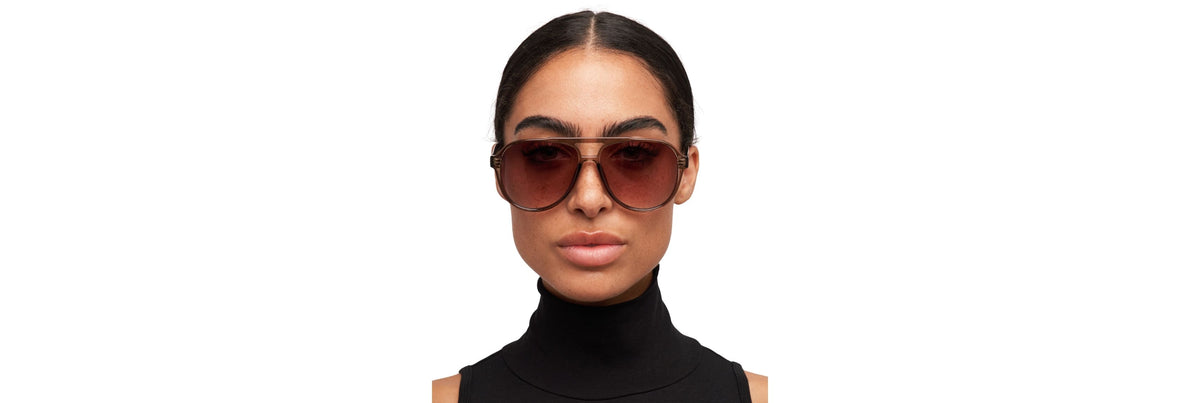 Close-up of sunglasses sliding into a structured hard case beside a soft vegan pouch and a car visor clip—three common storage options side by side.
