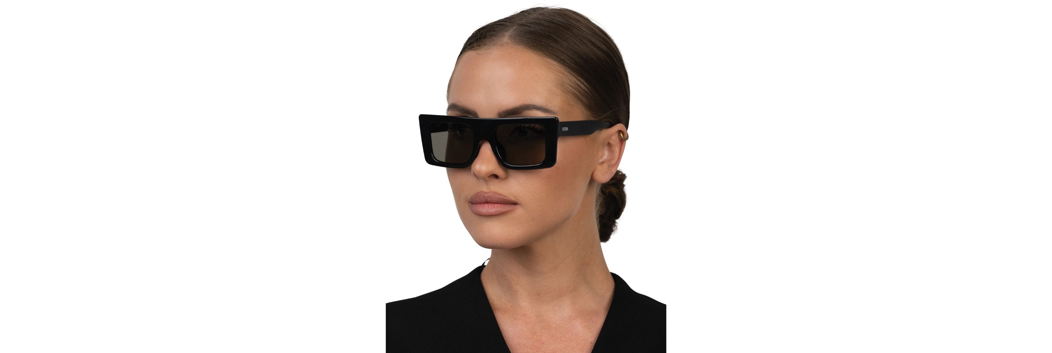 Close-up of sunglasses hinge and gently curved temple tips resting on a travel case, showing barrel hardware and smooth acetate finish.