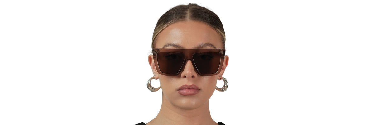 Hands cleaning sunglasses over a sink using a drop of mild dish soap and a microfiber cloth for a streak‑free finish.