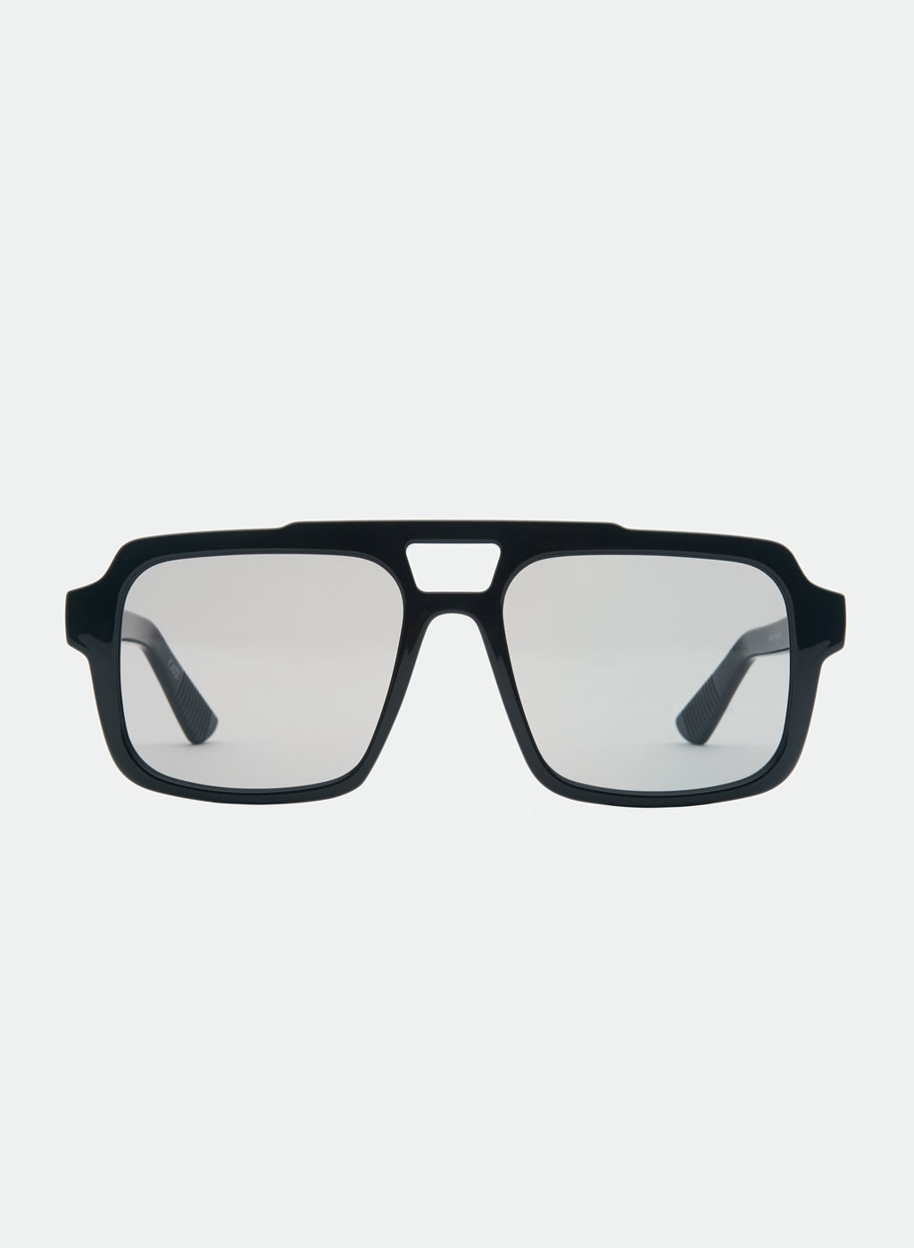 Otra Eyewear - TAME - Black/Smoke - Front view of TAME sunglasses in Black/Smoke featuring a lightweight black square aviator frame, dark smoke lenses, and a structured angular silhouette. A modern interpretation of the classic aviator designed for effortless everyday style in grey background