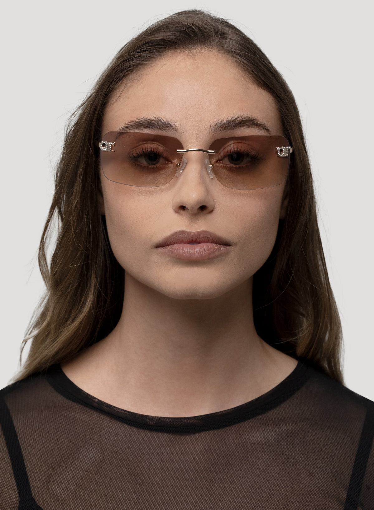 Model wearing Cara sunglasses in gold frame with brown lenses