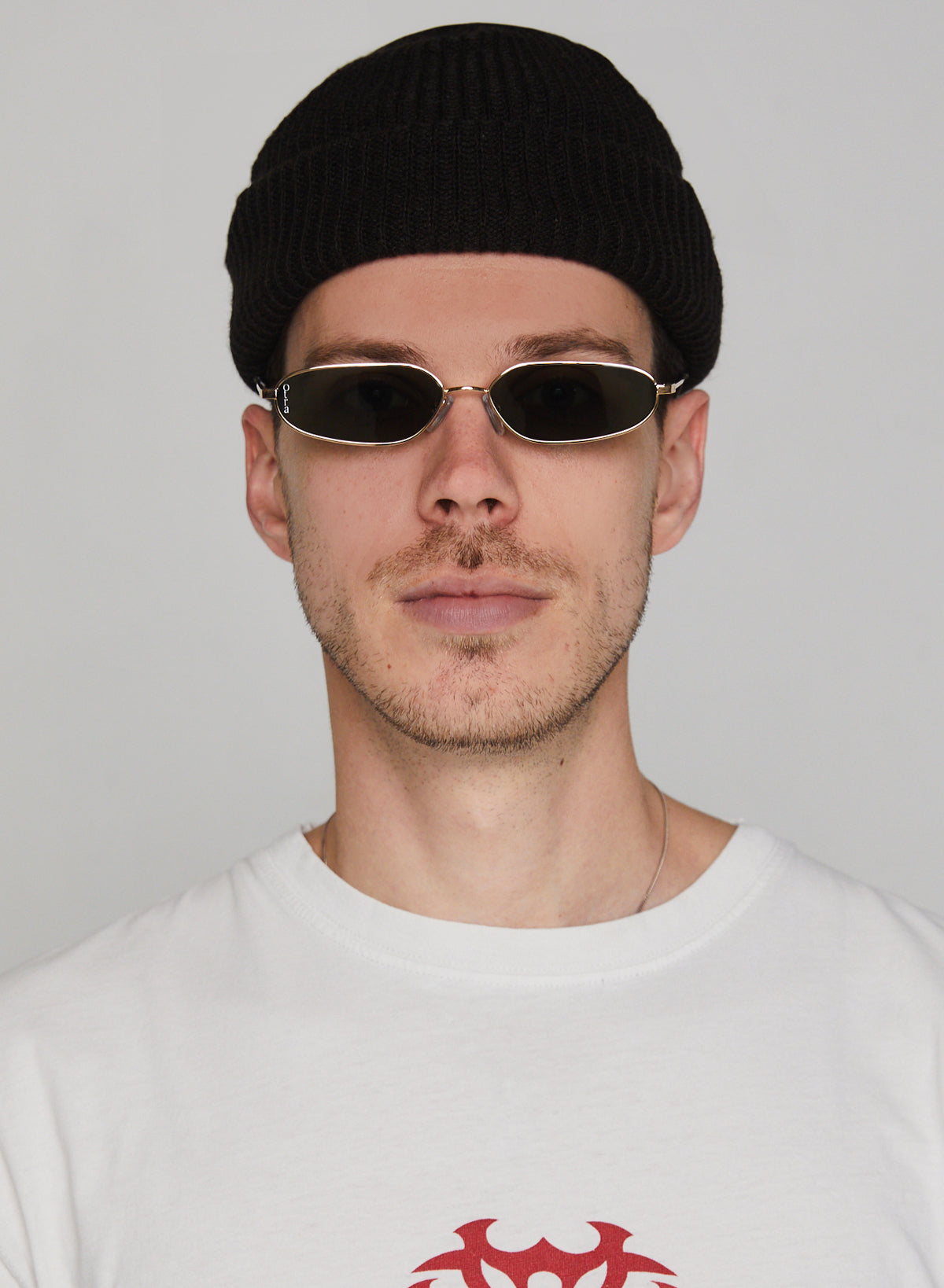Male model wearing Drew metal sunglasses with gold metal frame and green lenses