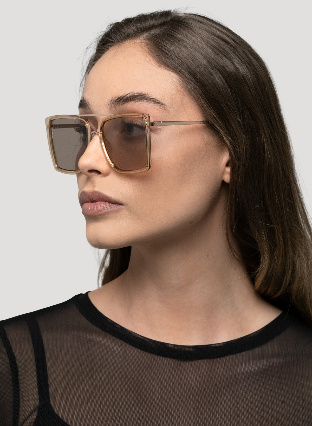 Side profile of model wearing Velda oversized square aviator sunglasses in gold