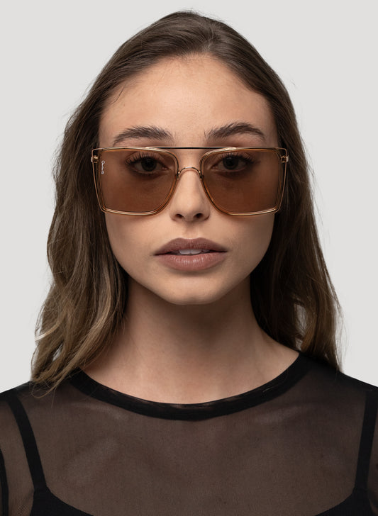 Model wearing Velda oversized square aviator sunglasses in gold